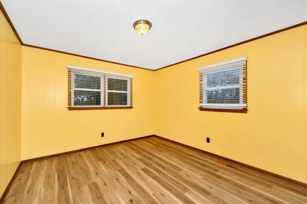 a view of a room with wooden floor and a window