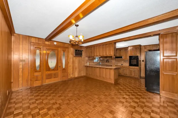 a large kitchen with stainless steel appliances kitchen island granite countertop a refrigerator and a sink