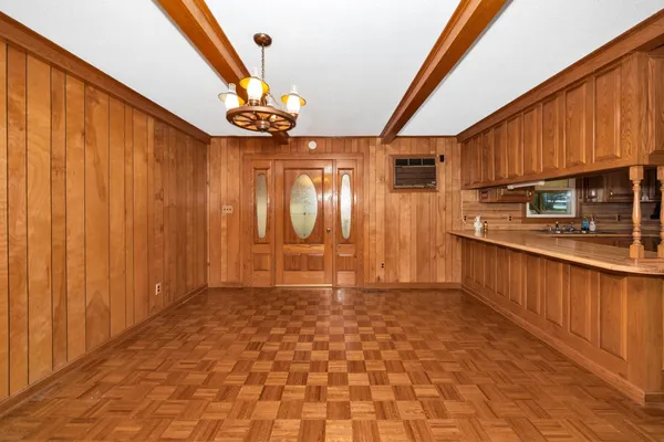 a view of a kitchen with stainless steel appliances wooden floor and staircase