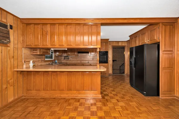 a kitchen with stainless steel appliances granite countertop a refrigerator a stove and a wooden cabinets