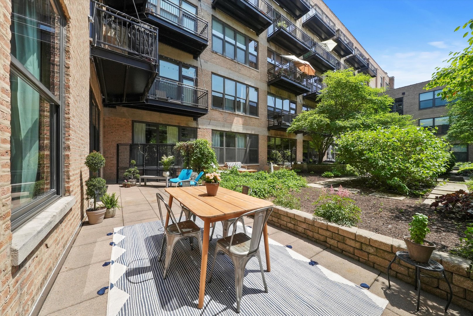 1040 West Adams Street, Unit 213 Chicago, IL 60607 - Photo 12 of 30 a view of a patio with couches table and chairs and potted plants