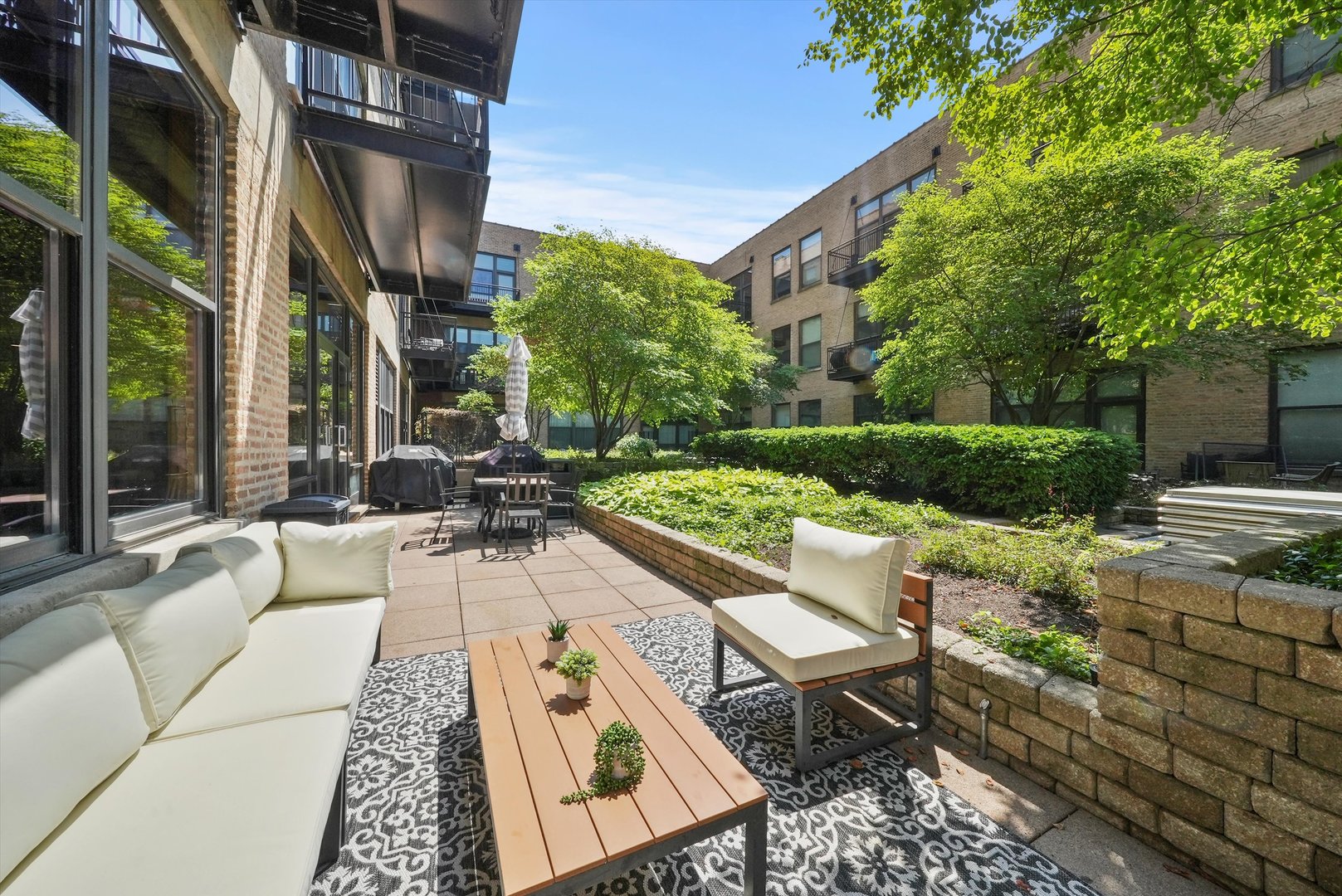 1040 West Adams Street, Unit 213 Chicago, IL 60607 - Photo 13 of 30 a view of a patio with couches and table and chairs next to yard