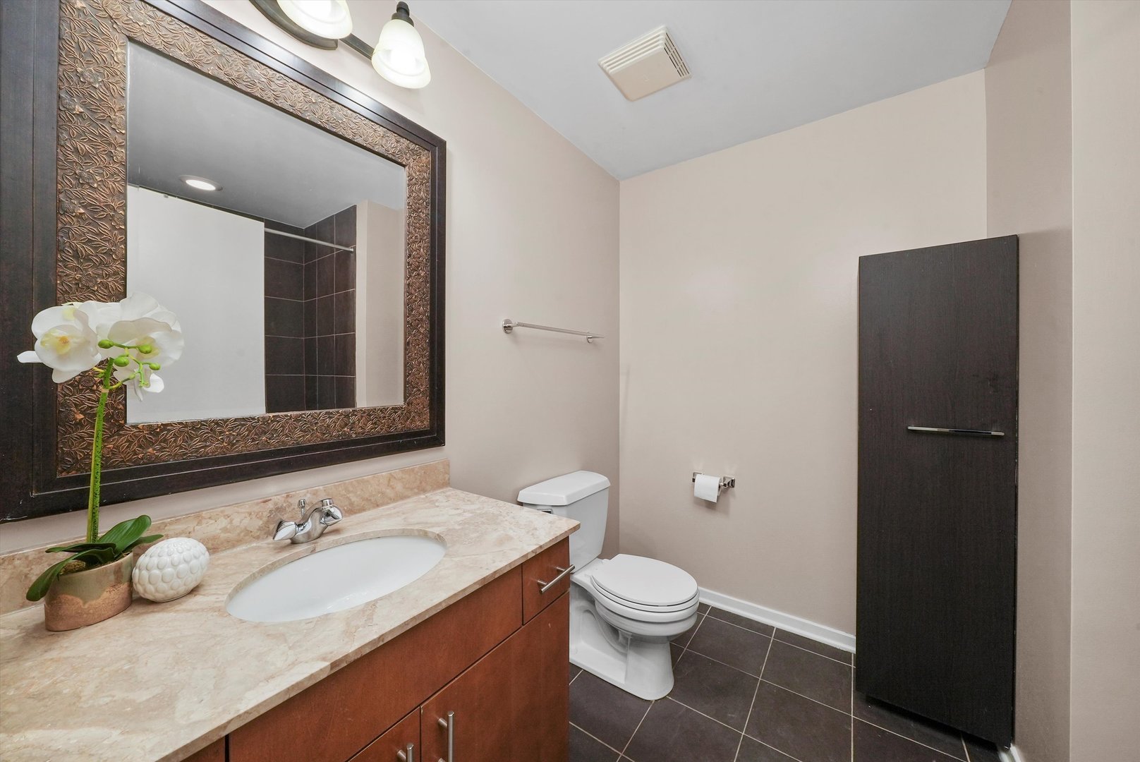 1040 West Adams Street, Unit 213 Chicago, IL 60607 - Photo 19 of 30 a bathroom with a granite countertop sink a large mirror and a toilet