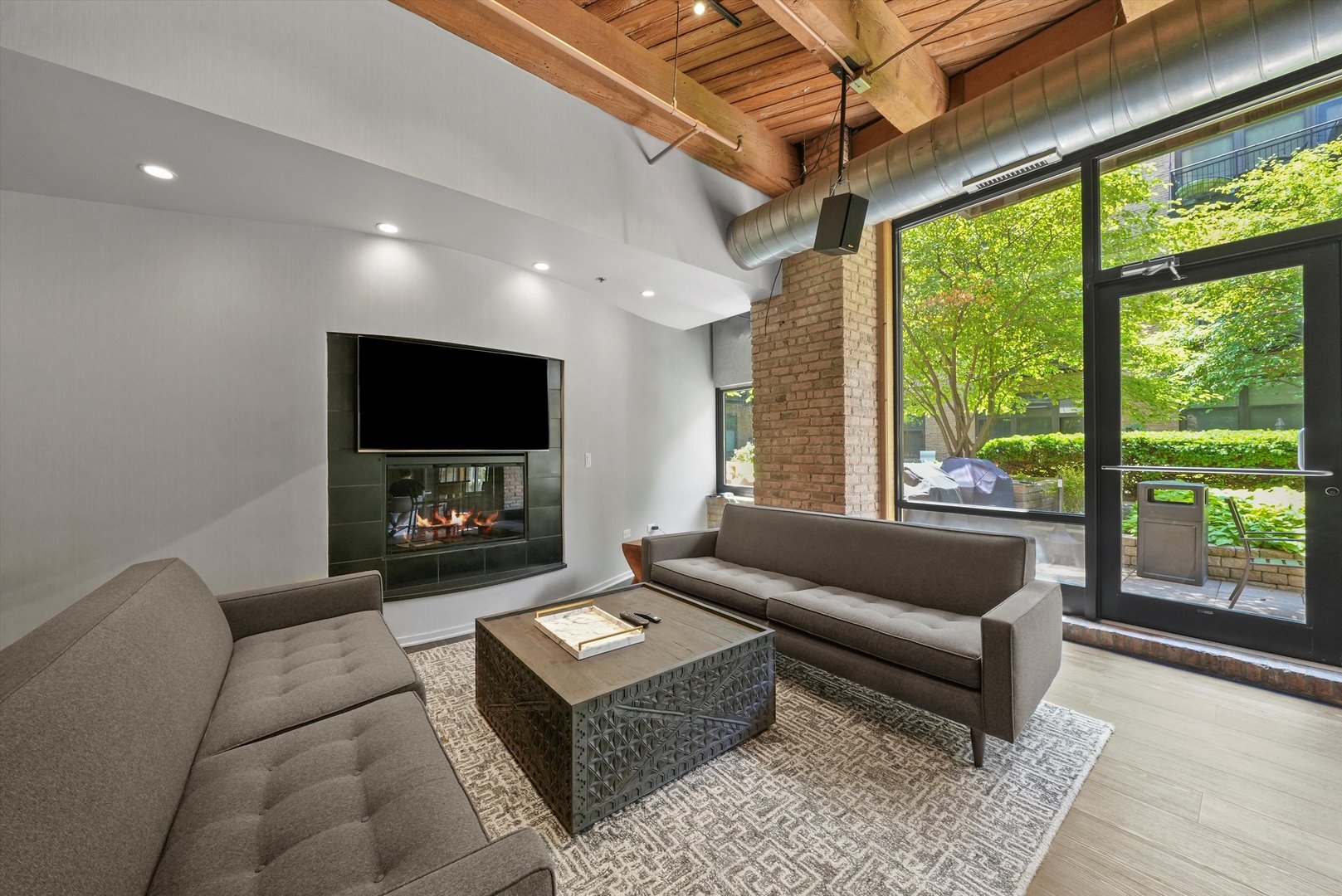 1040 West Adams Street, Unit 213 Chicago, IL 60607 - Photo 24 of 30 a living room with furniture a flat screen tv and a floor to ceiling window