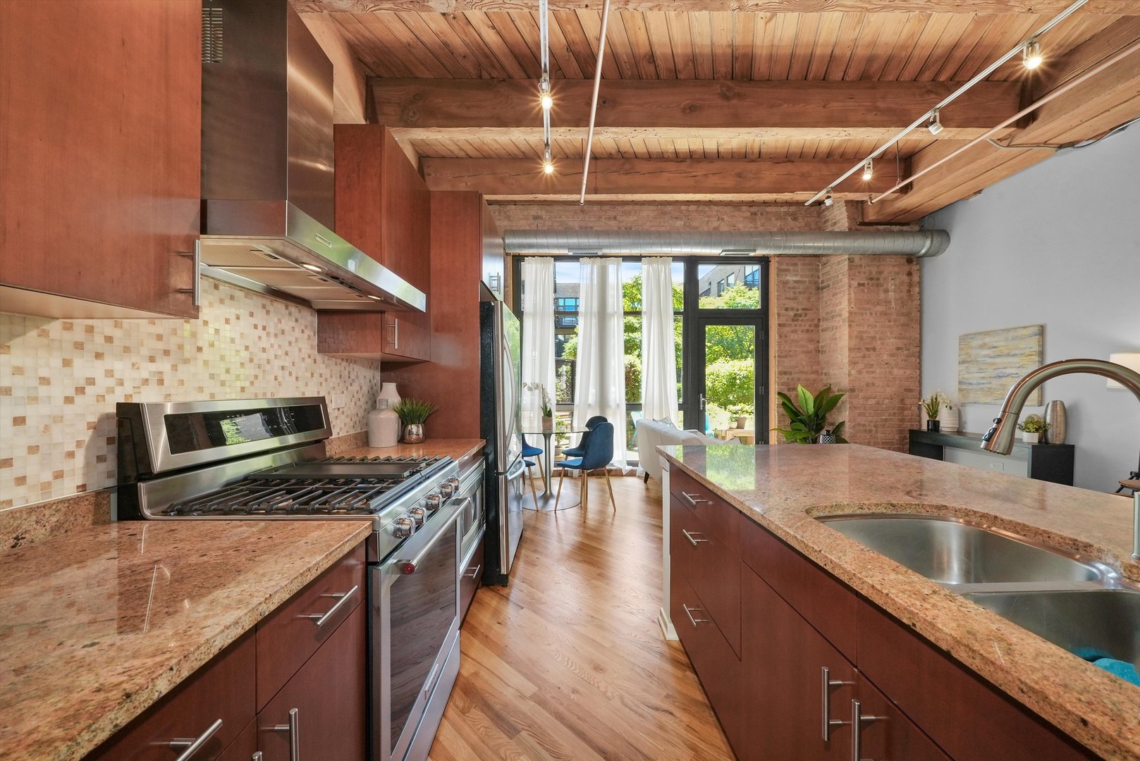 1040 West Adams Street, Unit 213 Chicago, IL 60607 - Photo 4 of 30 a kitchen with stainless steel appliances granite countertop a sink a stove and a wooden floors