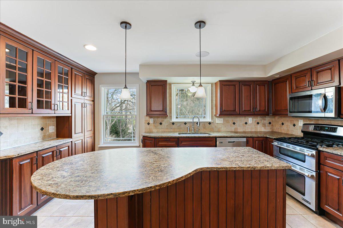 97 Quail Run Kennett Square, PA 19348 - Photo 5 of 34 a kitchen with stainless steel appliances granite countertop a sink a stove and a wooden floors