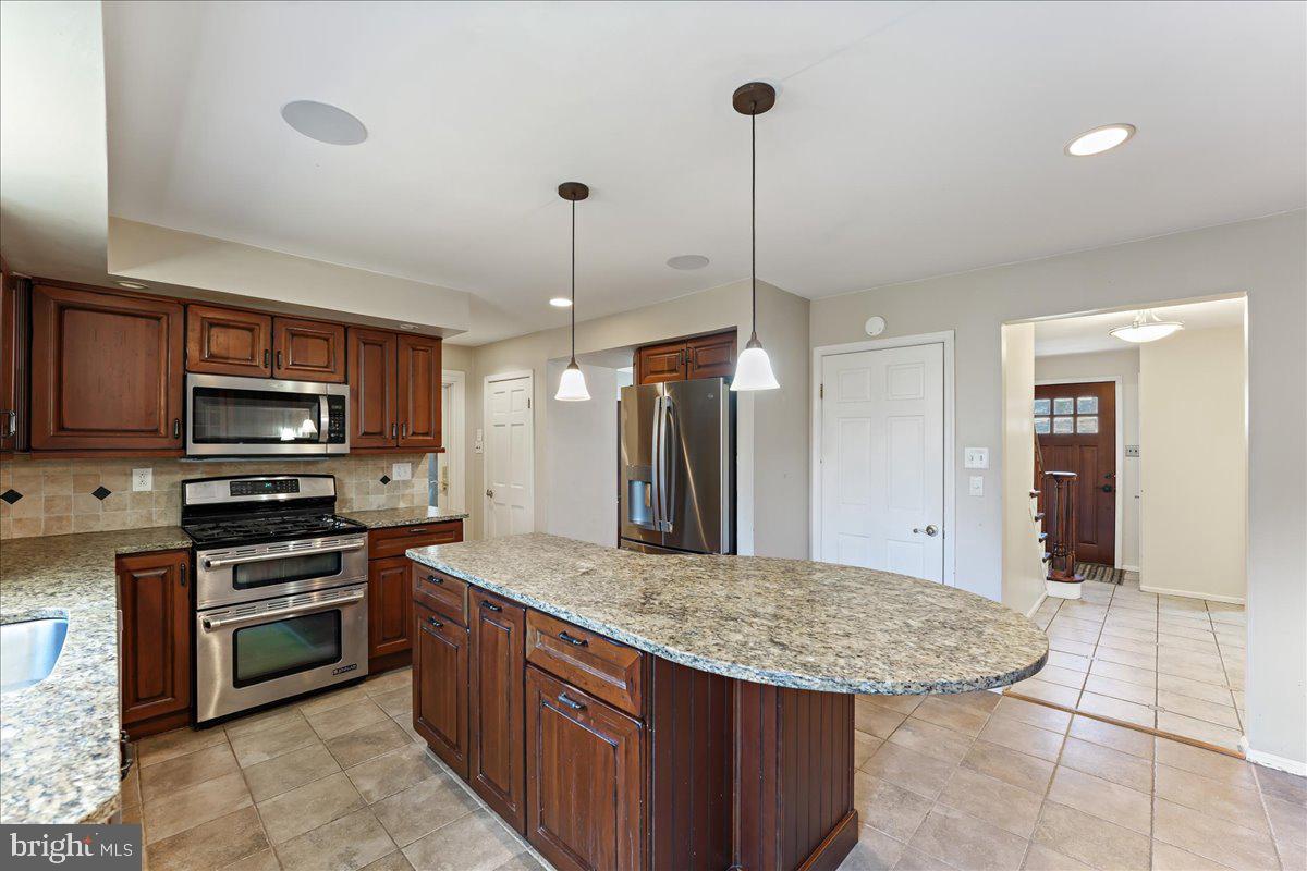 97 Quail Run Kennett Square, PA 19348 - Photo 6 of 34 a kitchen with stainless steel appliances granite countertop a stove a sink dishwasher a refrigerator and a oven with wooden floor