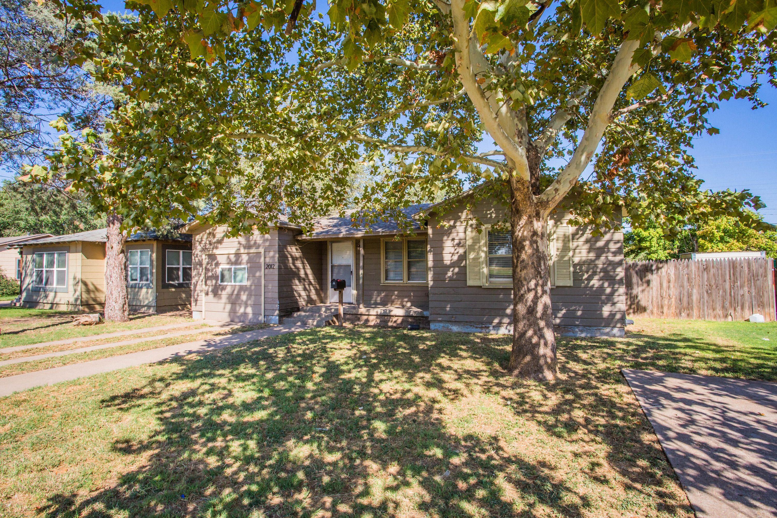 a front view of a house with a tree yard and outdoor seating