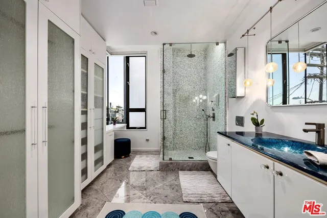 a bathroom with a granite countertop sink a mirror a bathtub and shower