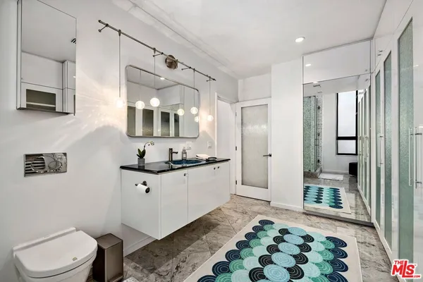 a spacious bathroom with a sink a toilet a mirror and shower