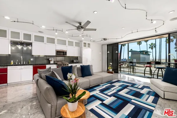 a living room with furniture kitchen view and large windows