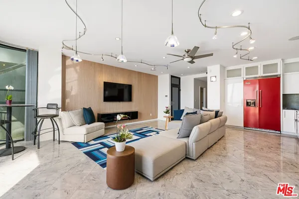 a living room with furniture a flat screen tv and a chandelier