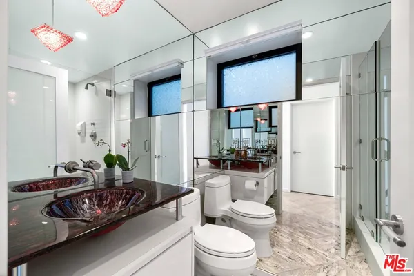 a living room with furniture and a glass door shower