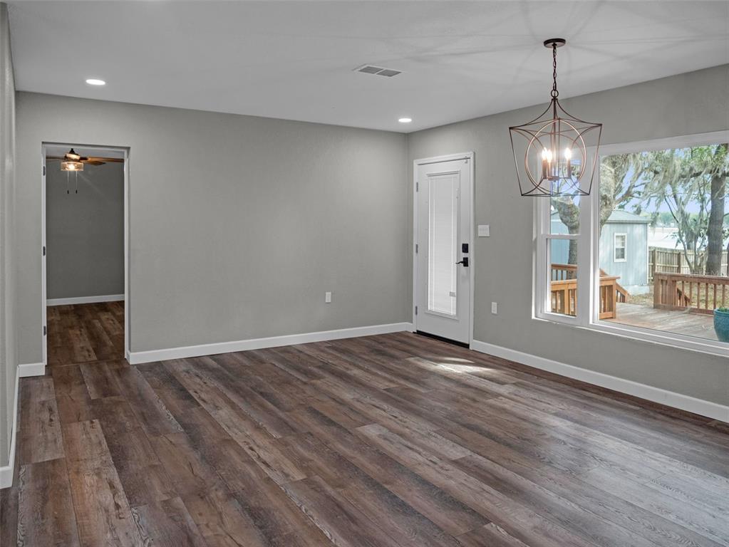 628 Bethel Street Keystone Heights, FL 32656 - Photo 11 of 49 a view of an empty room with wooden floor and a window