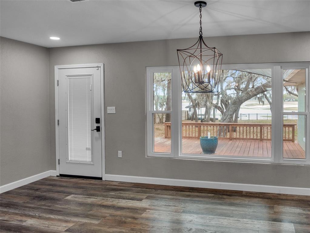 628 Bethel Street Keystone Heights, FL 32656 - Photo 12 of 49 a view of an empty room with wooden floor and a window