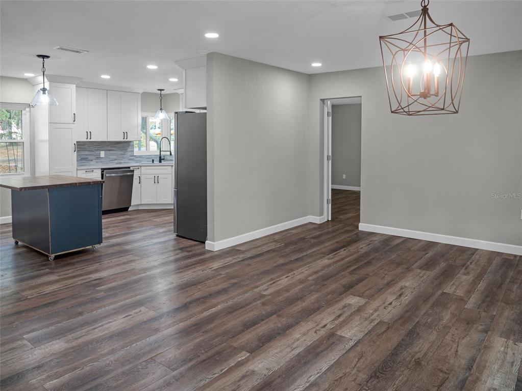 628 Bethel Street Keystone Heights, FL 32656 - Photo 13 of 49 a open kitchen with kitchen island a refrigerator and a wooden floor