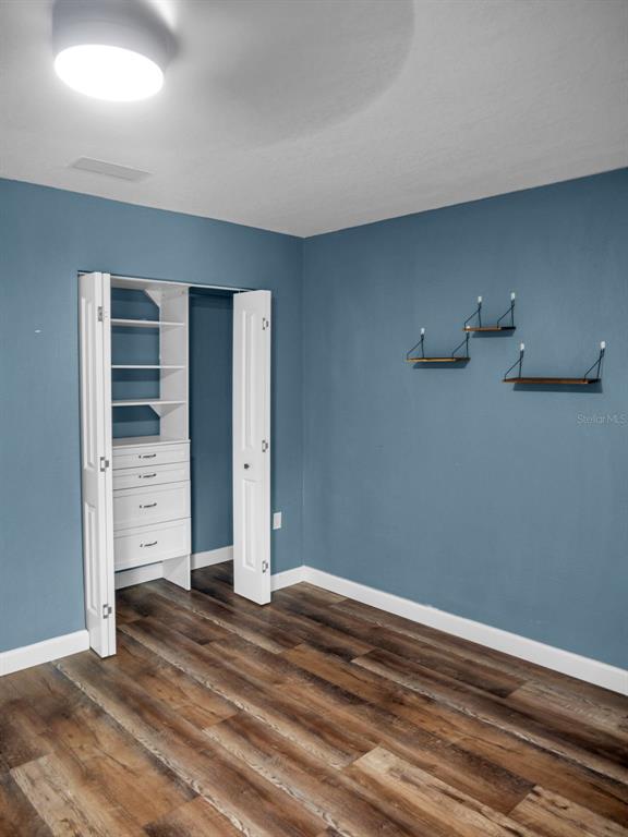 628 Bethel Street Keystone Heights, FL 32656 - Photo 25 of 49 an empty room with wooden floor and closet