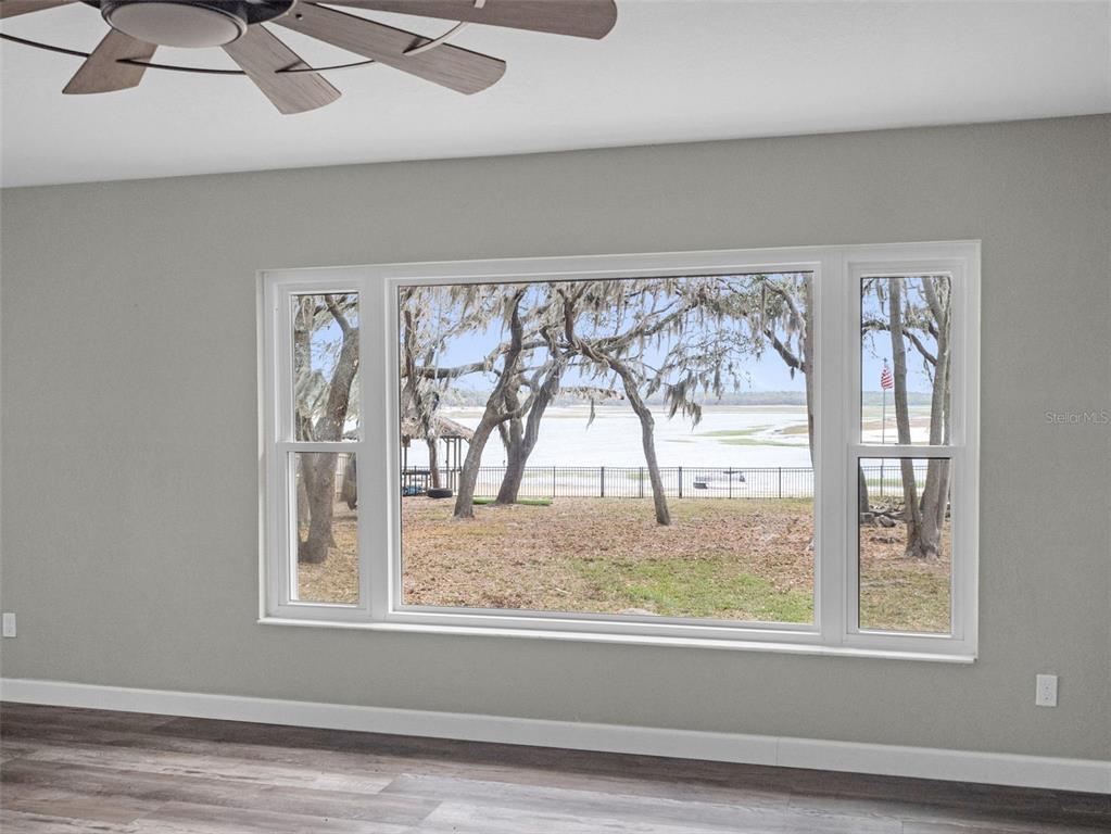 628 Bethel Street Keystone Heights, FL 32656 - Photo 30 of 49 an empty room with wooden floor and a floor to ceiling window