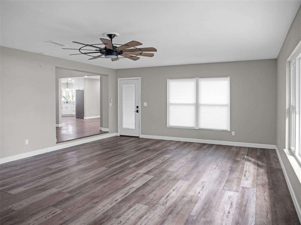 628 Bethel Street Keystone Heights, FL 32656 - Photo 31 of 49 an empty room with wooden floor chandelier fan and windows