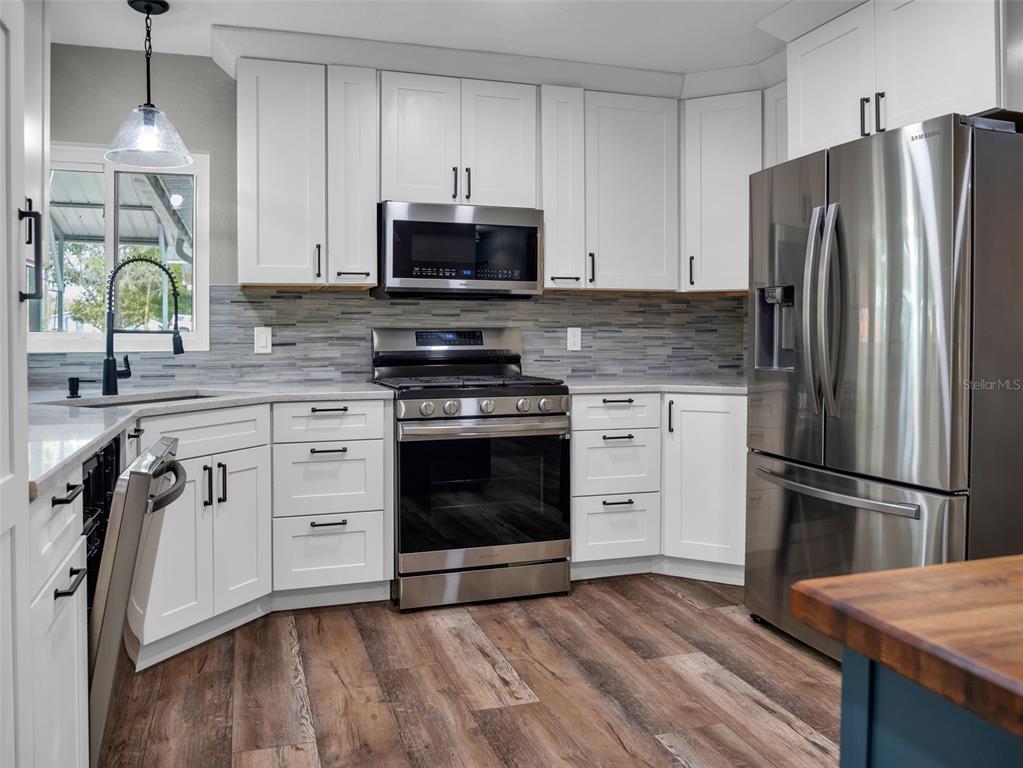 628 Bethel Street Keystone Heights, FL 32656 - Photo 6 of 49 a kitchen with cabinets stainless steel appliances and wooden floor