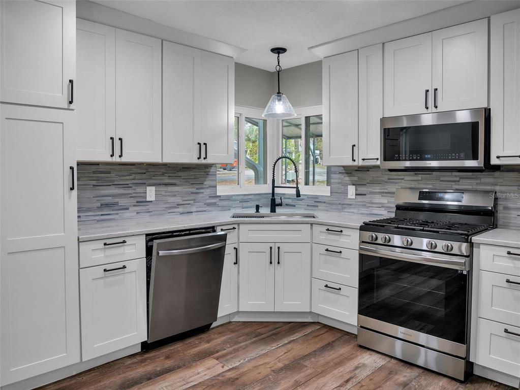 628 Bethel Street Keystone Heights, FL 32656 - Photo 8 of 49 a kitchen with granite countertop a stove a sink and a microwave