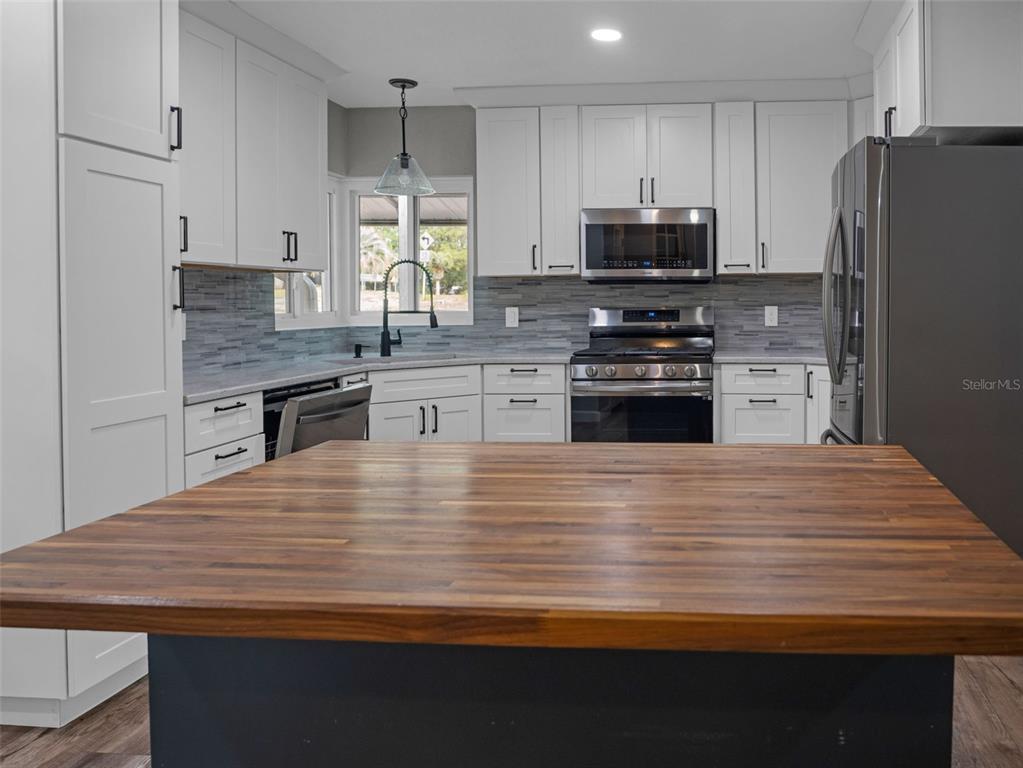 628 Bethel Street Keystone Heights, FL 32656 - Photo 9 of 49 a kitchen with granite countertop wooden cabinets and stainless steel appliances
