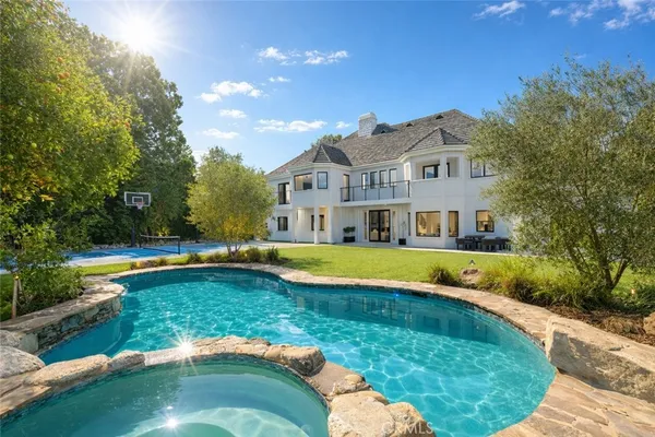 a view of a house with swimming pool and a yard