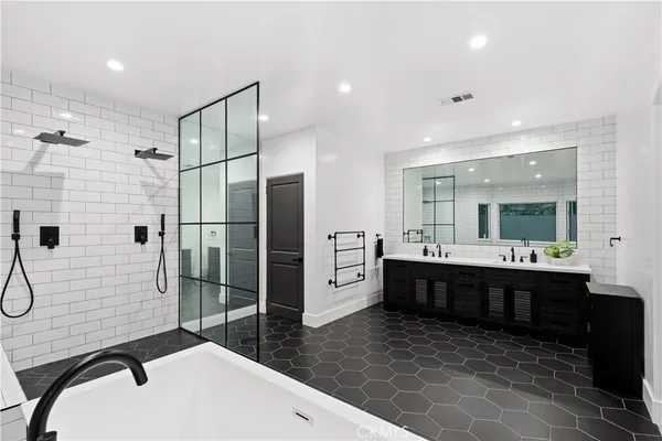 a large bathroom with a double vanity sink toilet mirror and bathtub
