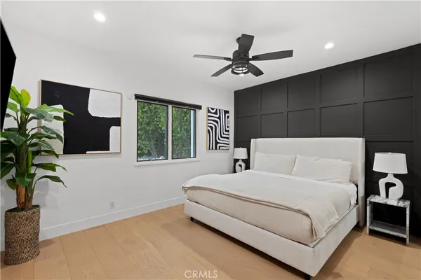 a bedroom with a large bed and a potted plant
