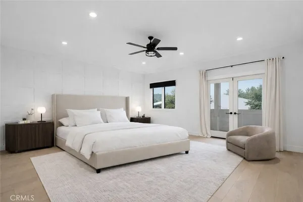 a bedroom with a large bed and a chandelier