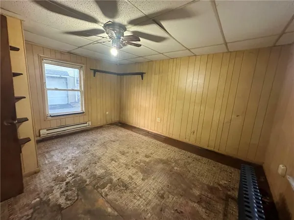 an empty room with windows and fan