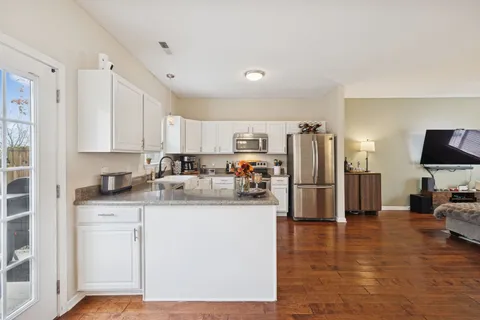 a kitchen with stainless steel appliances granite countertop a refrigerator stove microwave and sink