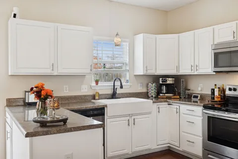 a kitchen with stainless steel appliances granite countertop a sink a stove and cabinets