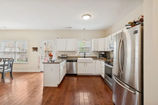 a kitchen with white cabinets and stainless steel appliances