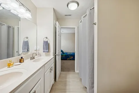 a en suite bathroom with a double vanity sink and mirror