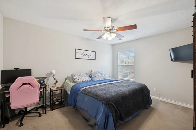 a bedroom with a bed a chandelier and a window
