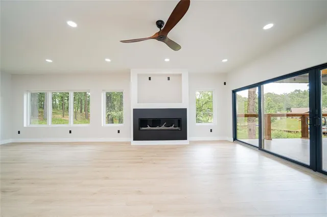 a view of an empty room with a fireplace and a window