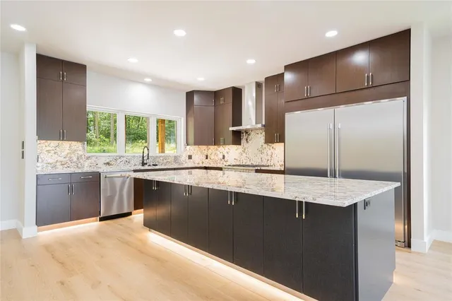 a kitchen with stainless steel appliances granite countertop a sink and stove
