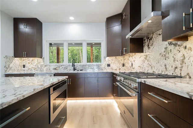 a kitchen with stainless steel appliances granite countertop a sink and stove