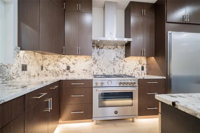 a kitchen with stainless steel appliances granite countertop a stove and a refrigerator