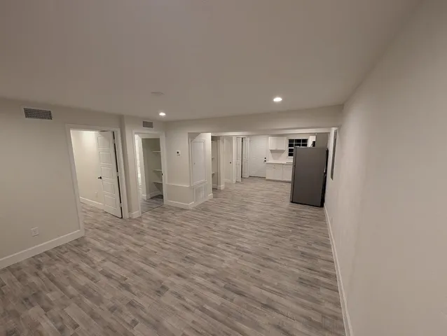 a view of empty room with wooden floor