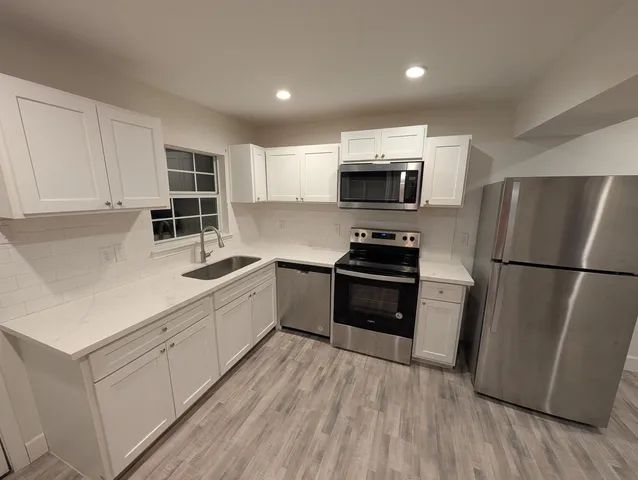 a kitchen with stainless steel appliances a refrigerator sink and microwave