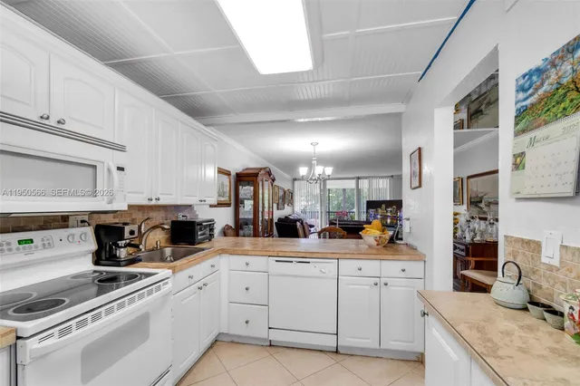 a kitchen with white cabinets and white appliances