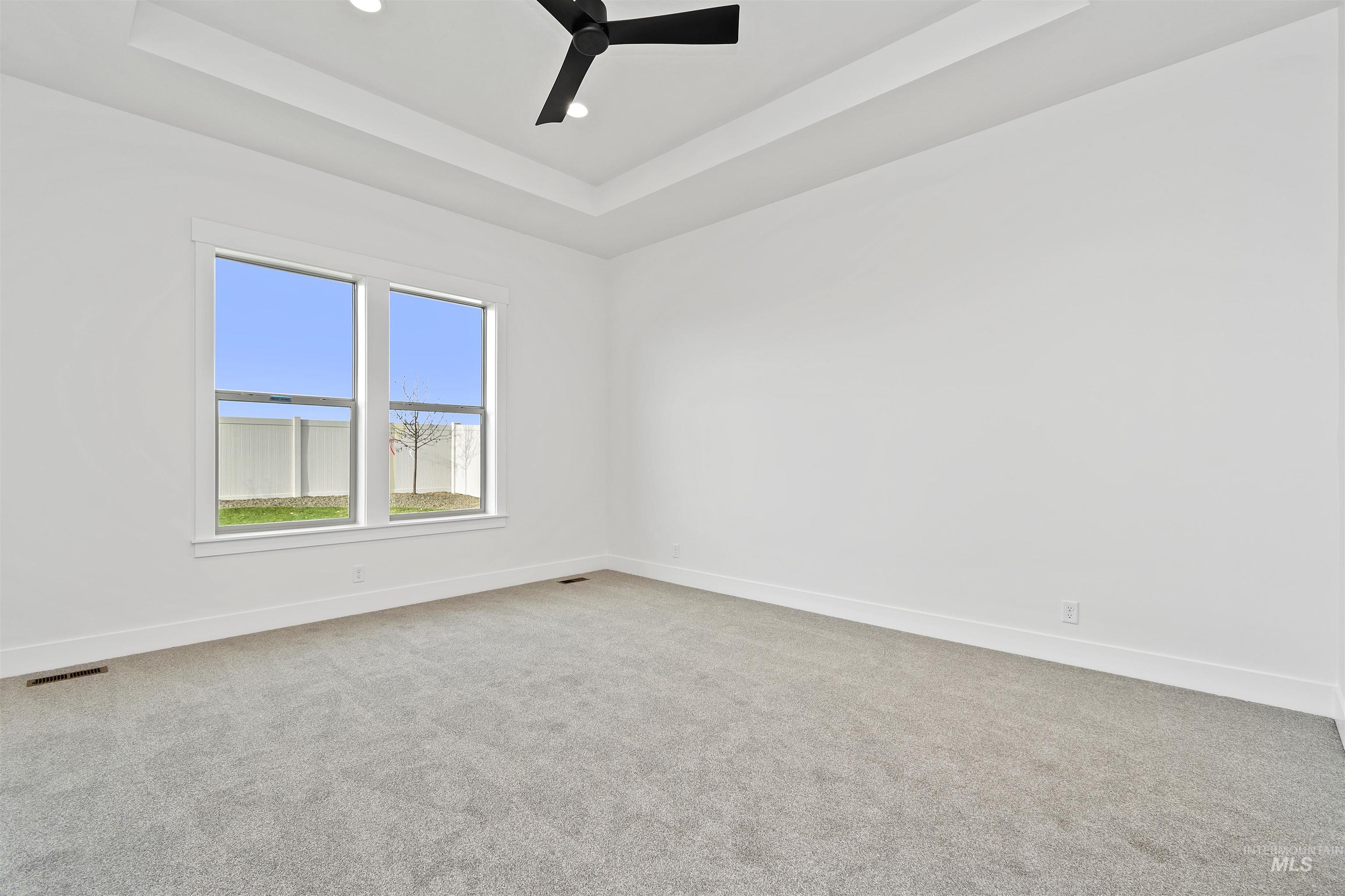 3875 South Corabell Avenue Meridian, ID 83642 - Photo 17 of 27 Spare room featuring a raised ceiling, light colored carpet, a ceiling fan, and recessed lighting