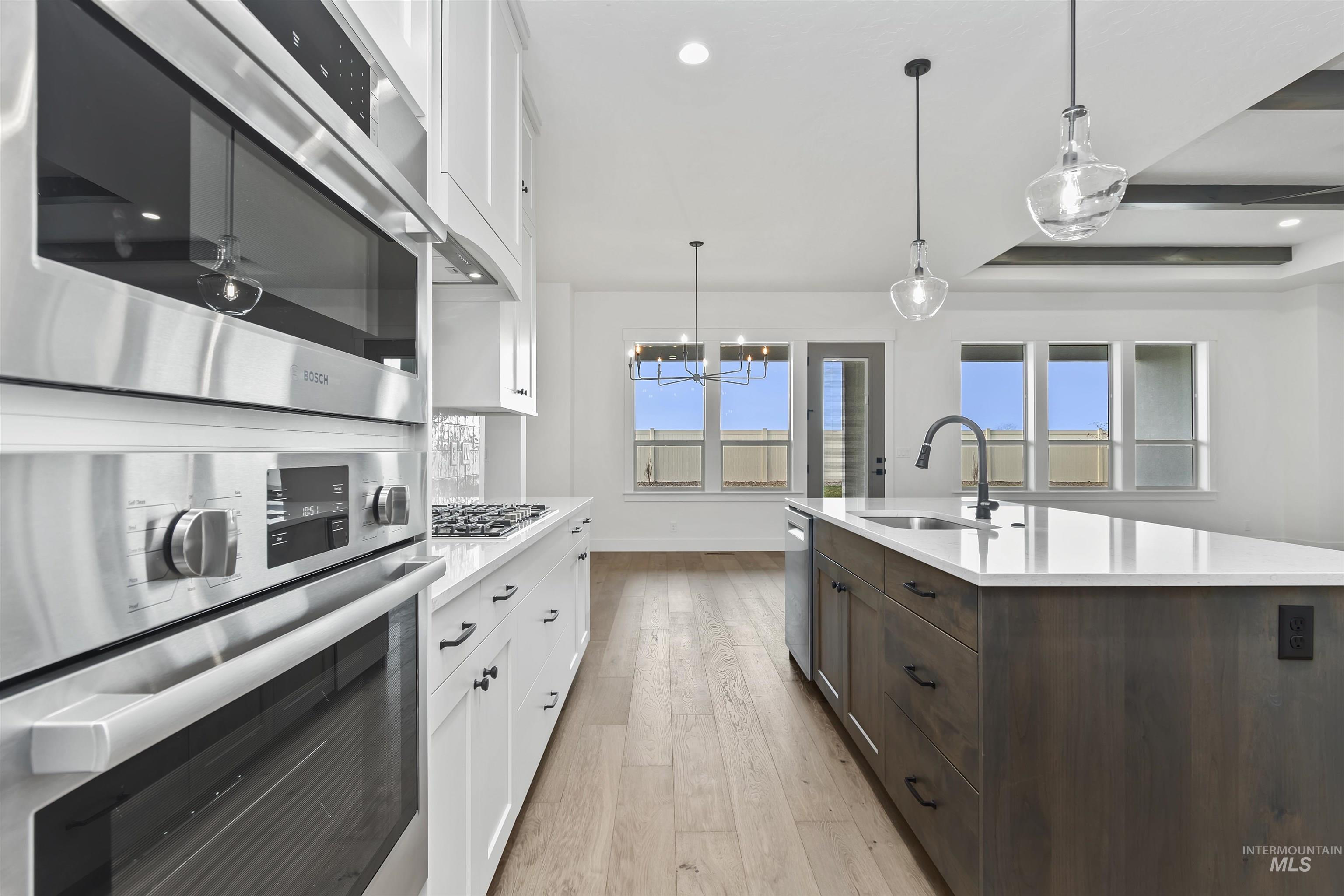 3875 South Corabell Avenue Meridian, ID 83642 - Photo 6 of 27 Kitchen with white cabinets, dark brown cabinetry, pendant lighting, stainless steel appliances, and recessed lighting