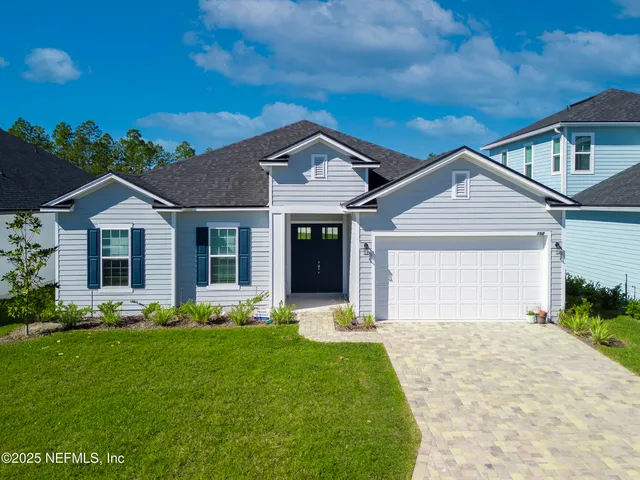 a front view of a house with a garden and plants