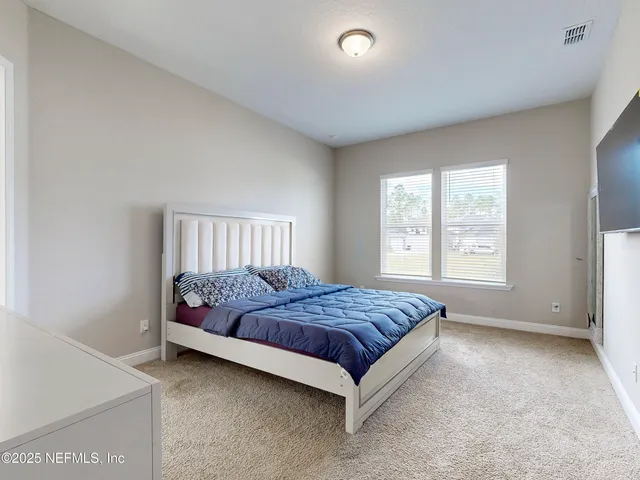a bed sitting in a bedroom next to a window
