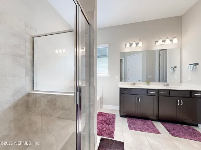 a spacious bathroom with a bathtub sink and mirror