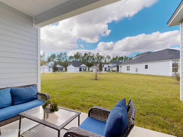 a view of a house with a yard and large trees