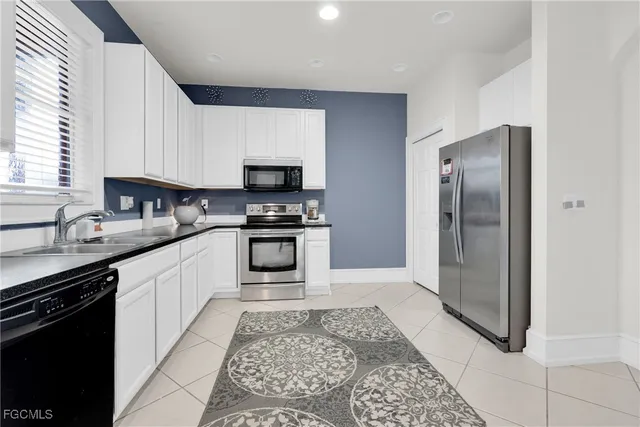 a kitchen with granite countertop a sink cabinets and stainless steel appliances